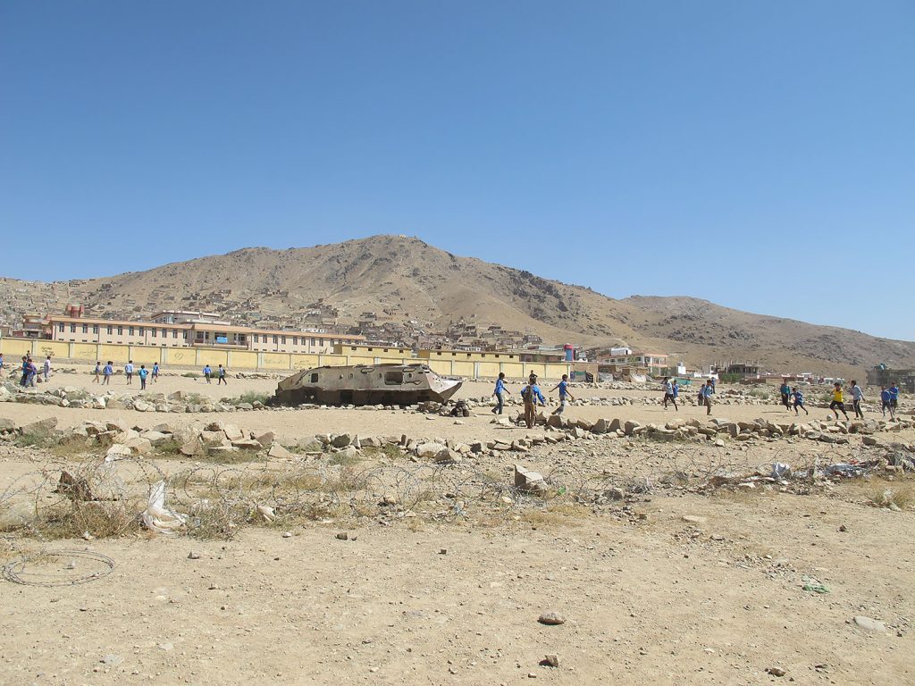 Rusty Soviet military vehicle in a barren field in Khair Khana, Kabul