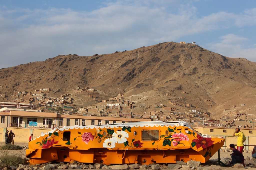 Colorfully painted Soviet military vehicle with children in Khair Khana, Kabul